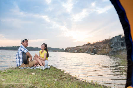 Young man playing guitar and singing for his laughing girlfriendの写真素材