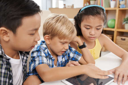 Multi-ethnic group of children drawing on digital tabletの写真素材