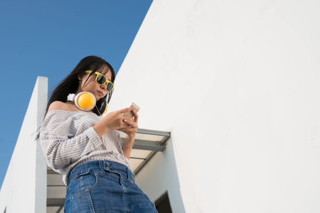 Portrait of stylish girl texting, view from below