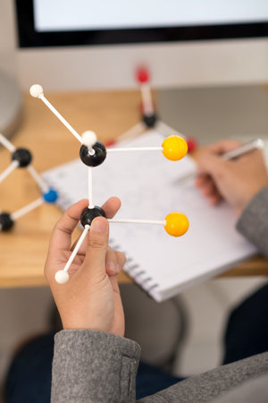 Researcher making notes when analyzing molecular model