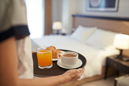 Waitress bringing breakfast to the hotel roomの写真素材