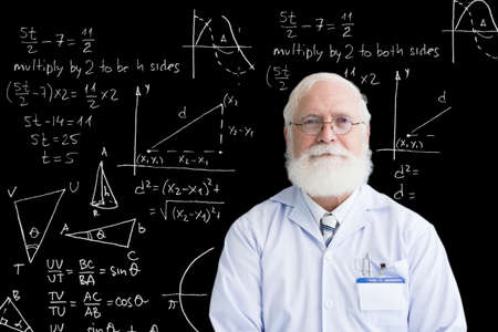 Portrait of mature mathematician against blackboard with formulas and chartsの写真素材