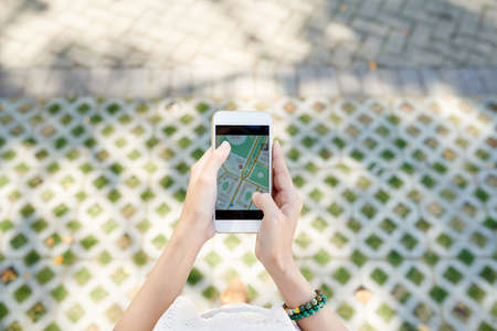 Hands of traveller using GPS navigator application in a cityの写真素材