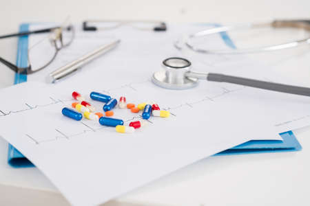 Cardiogram, stethoscope and different pills to prevent heart diseaseの写真素材