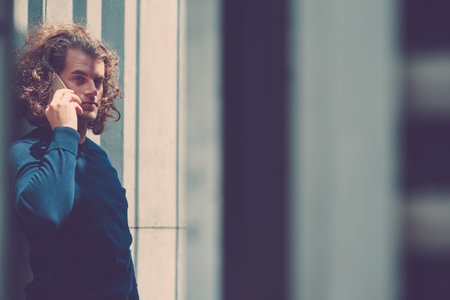 Portrait of handsome Caucasian man calling on the phone and looking at cameraの写真素材