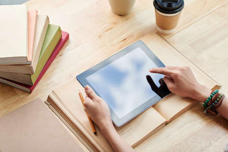 Student using application on digital tablet, view from aboveの写真素材