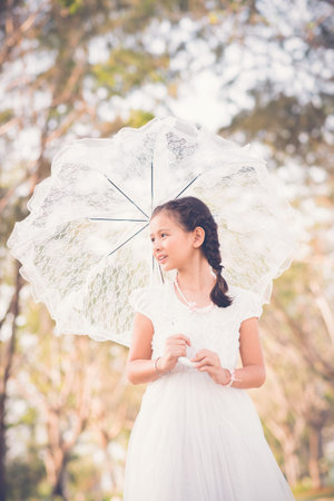 Portrait of mixed-race girl with lace umbrellaの写真素材