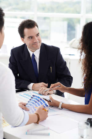 Businessman talking to creative team in design studioの写真素材