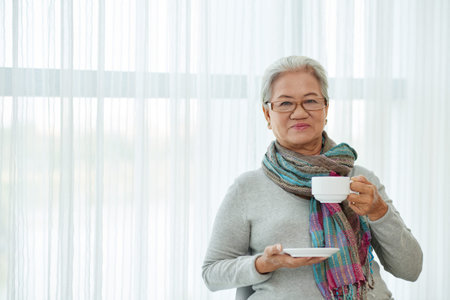 Portrait of smiling senior woman drinking coffee