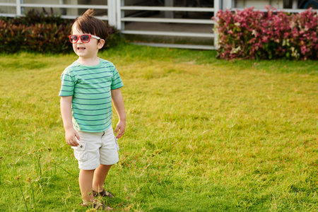Cheerful little kid in sunglasses playing in backyardの写真素材
