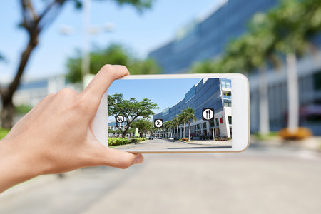 Woman using application to observe infrastructure in the streetの写真素材