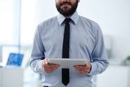 Cropped image of business executive with digital tablet in his handsの写真素材