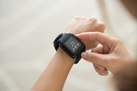 Hands of woman using music player, on her smart watch