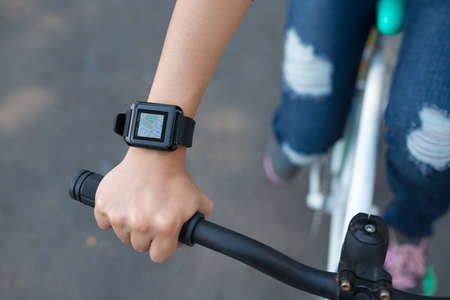 Girl riding bicycle with map in her smart watchの写真素材