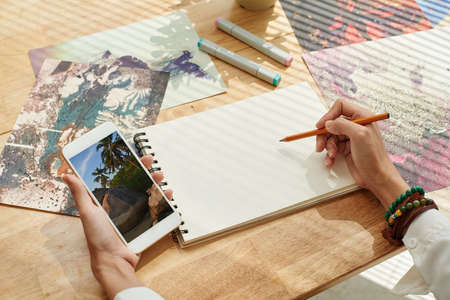 Artist copying picture from his smartphoneの写真素材