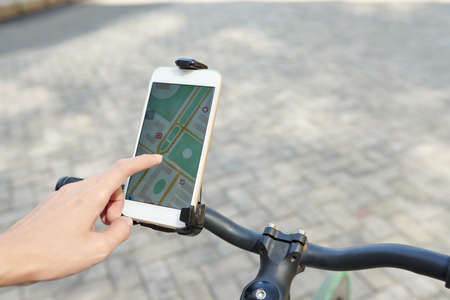 Woman using GPS navigator in her phone when cycling in the cityの写真素材