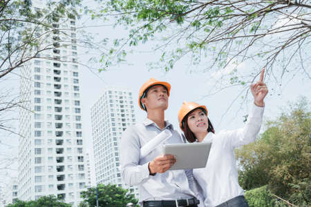 Team of architects with digital tablet examining construction siteの写真素材
