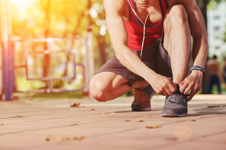 Jogger tying shoe laces before jogging