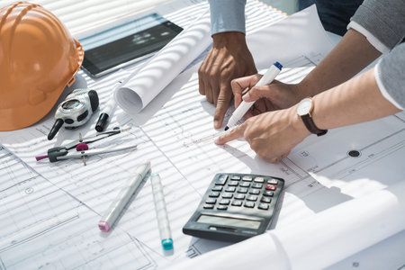 Hands of engineers making corrections in blueprintの写真素材