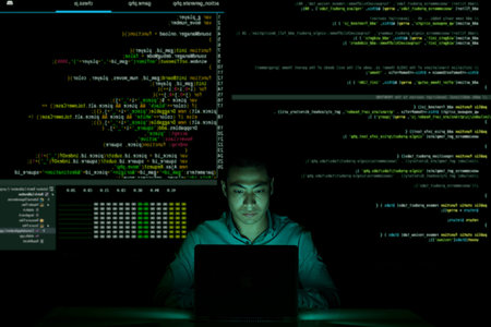 Asian developer coding in dark office