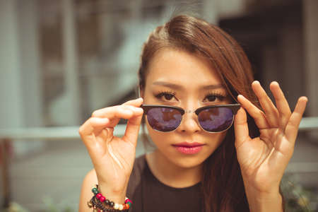 Beautiful Vietnamese woman with sunglasses looking at cameraの写真素材