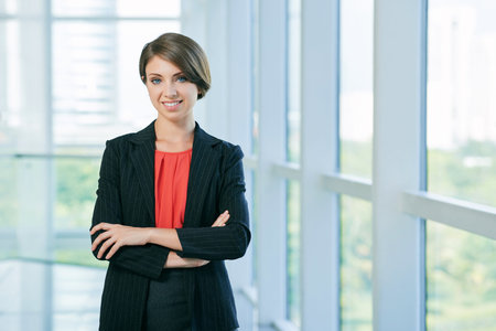 Lovely young business woman standing with her arms crossed
