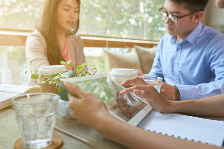 Close-up image of woman using tablet computer when meeting with friends