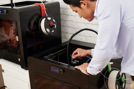 Designer loading white filament in 3D printer