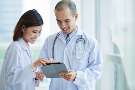 Smiling medical workers reading something on tablet computerの写真素材