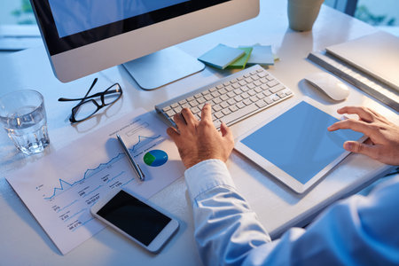 Cropped image of entrepreneur using computer and digital tablet in his work