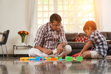 Father and his little son building a house of plastic blocksの写真素材