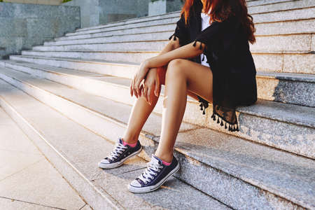 Close-up of woman sitting on stairs outdoorsの写真素材