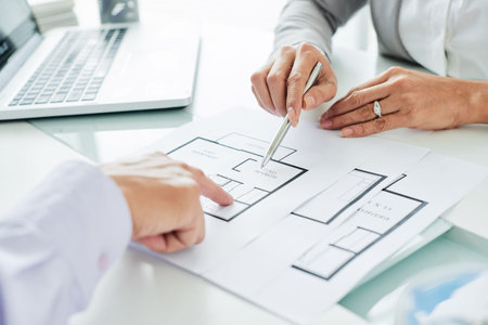 Realtor showing the plan of apartment to her client