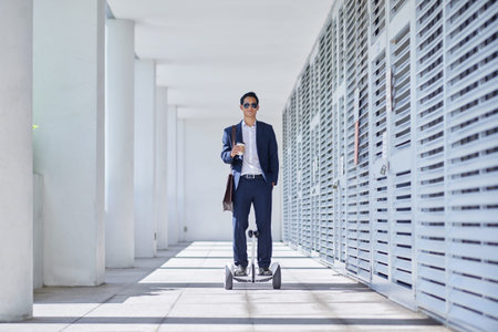Businessman in sunglasses standing on segway