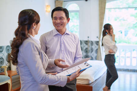 Realtor showing the plan of apartment to her clientの写真素材