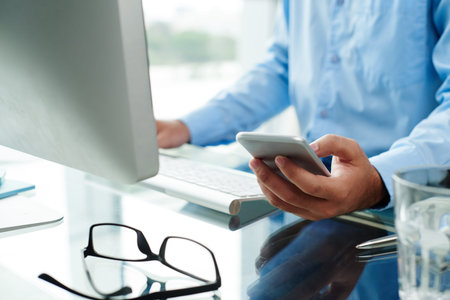 Businessman reading message on his phone when working