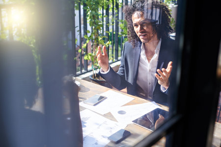 Hipster businessman at meeting with partner in cafeの写真素材