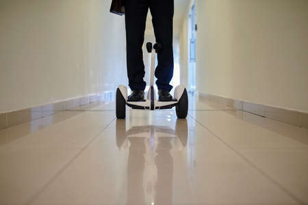 Legs of businessman during ride on segway indoorsの写真素材