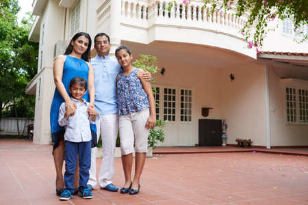 Portrait of family standing outside dream homeの写真素材