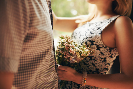Cropped image of woman with bouquet of flowers hugging her boyfriendの写真素材