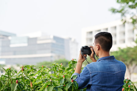 Man enjoying photographing plants in the city