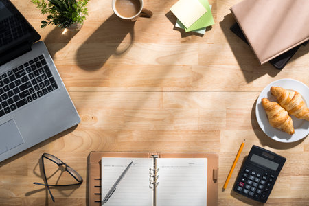 Various office supplies on wooden desk, view from above