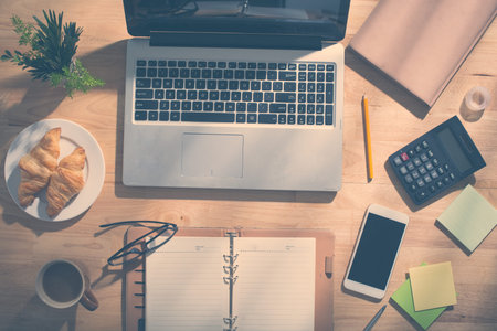 Laptop, planner and various supplies on desk of entrepreneurの写真素材