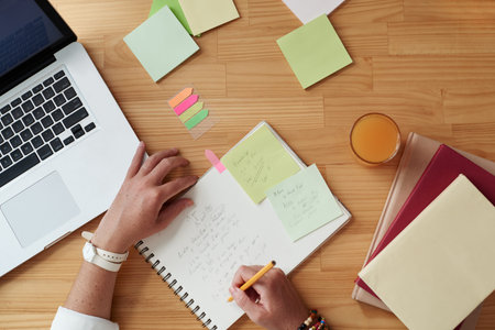 Woman writing plans for the day in her notepad, view from above