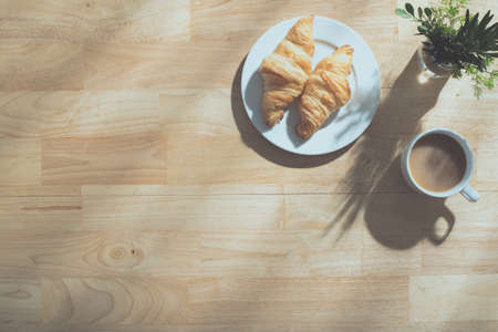 Delicious breakfast: two croissants and cappuccino on tableの写真素材