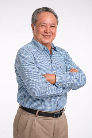 Confident mature Vietnamese man standing with his arms crossedの写真素材