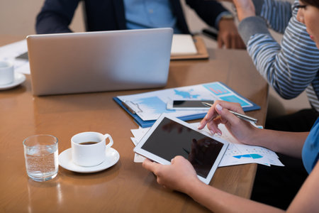 Close-up image of business lady using digital tablet at meetingの写真素材