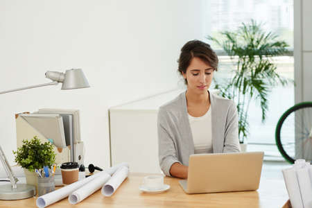 Architect working on laptop at her deskの写真素材