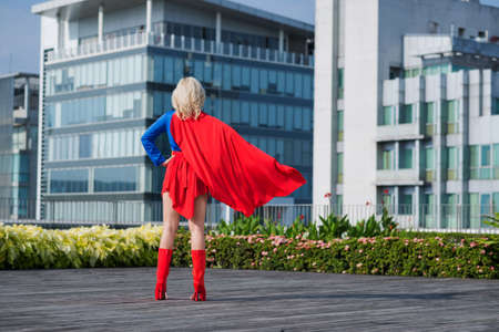 Rear view of superwoman looking at the cityの写真素材