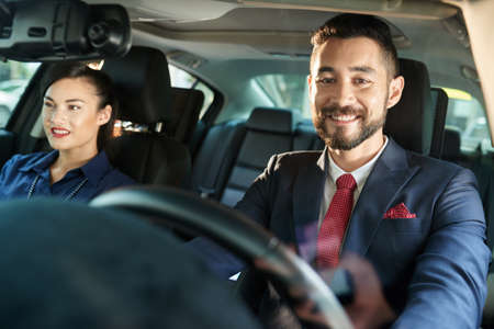 Smiling business couple sitting in carの写真素材